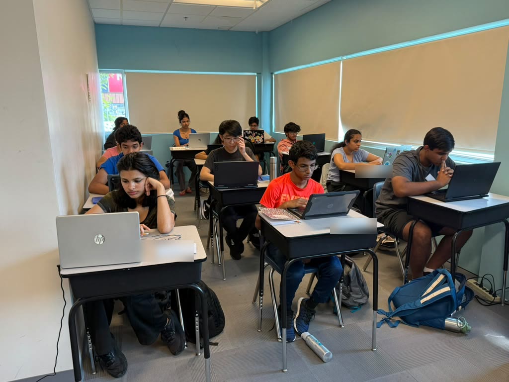 Students working on practice questions on laptops during a class at Y2 Academy